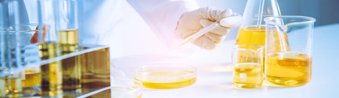 Výzkumník provádějící analýzu oleje s pipetou a Petriho miskou
