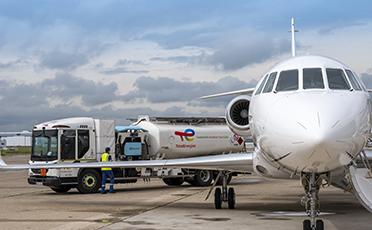 Cisterna s udržitelným palivem TotalEnergies doplňující nádrž dopravního letadla