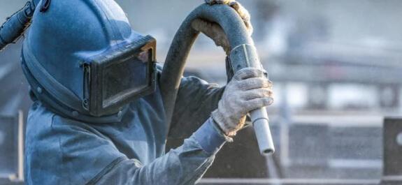 Pracovník v ochranném oděvu nanáší olej Osyris