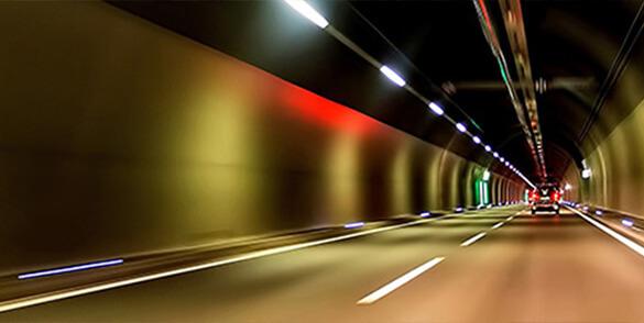 Osvětlený tunel s projíždějícím autem
