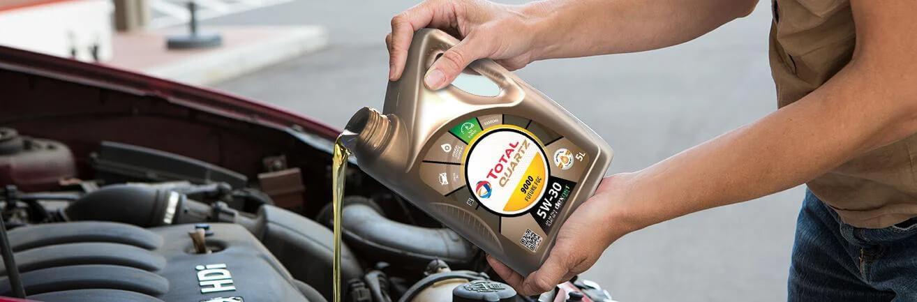 Doplňování motorového oleje do automobilu